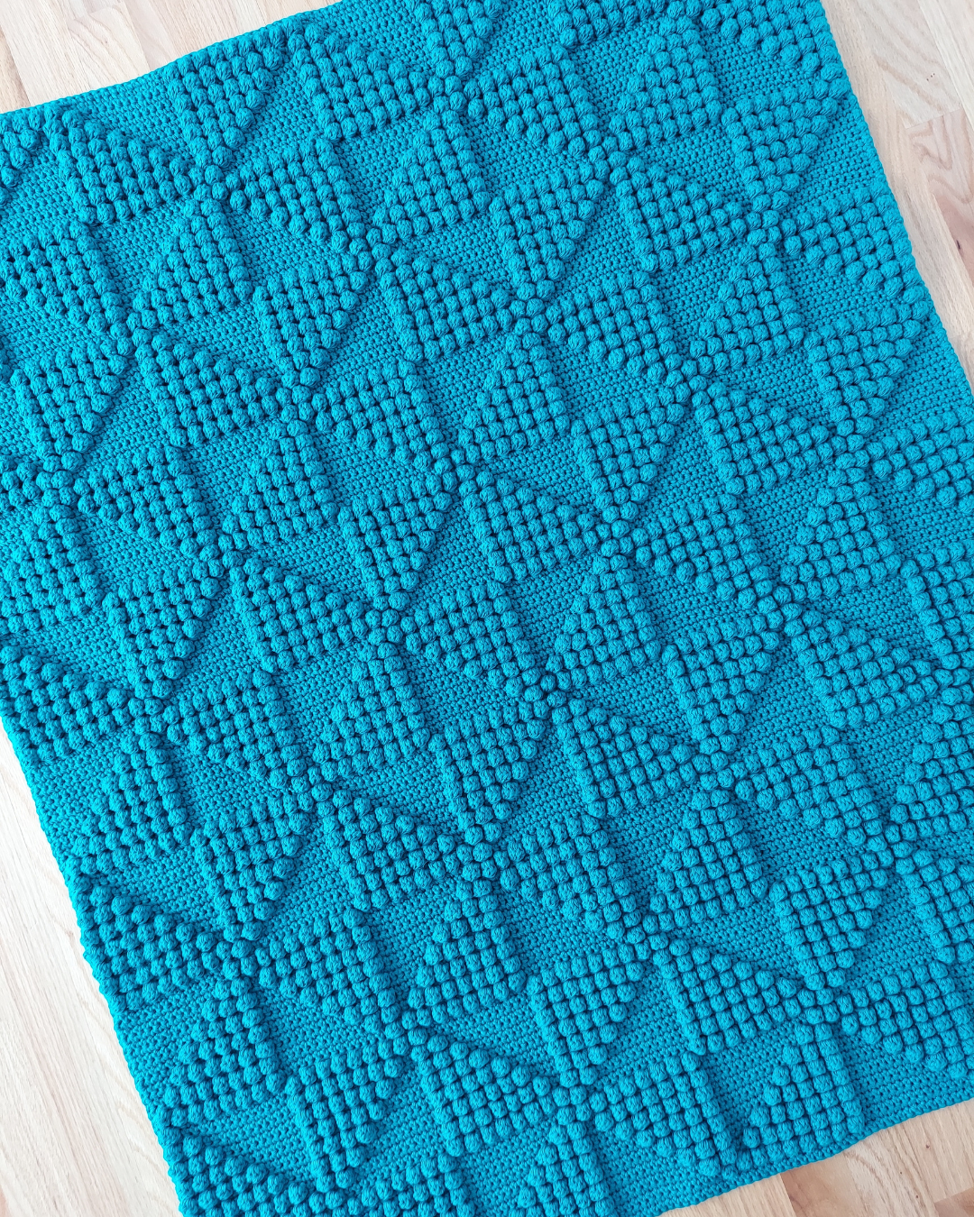 teal blanket with pinwheel design